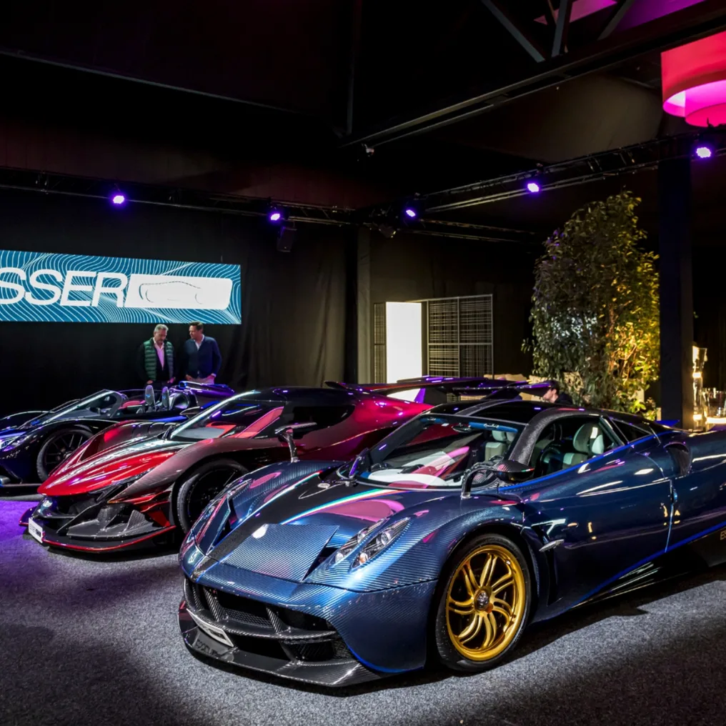 Supercars lined up under coloured lighting in the InterClassics foyer, next door to Sim Formula Europe